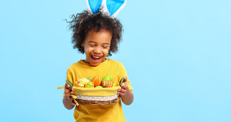 Cheerful ethnic kid holding Easter present in hands and laughing