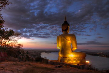 Giant Golden Buddha statue at sunset in Pakse Laos Mekong River