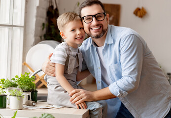 Boy sitting on fathers hands and hugging