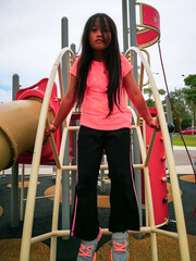 beautiful young girl with long hair active on playground