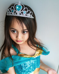 Portrait of a little girl dressed in arabian princess costume against white background. Natural light, selective focus. © ellinnur