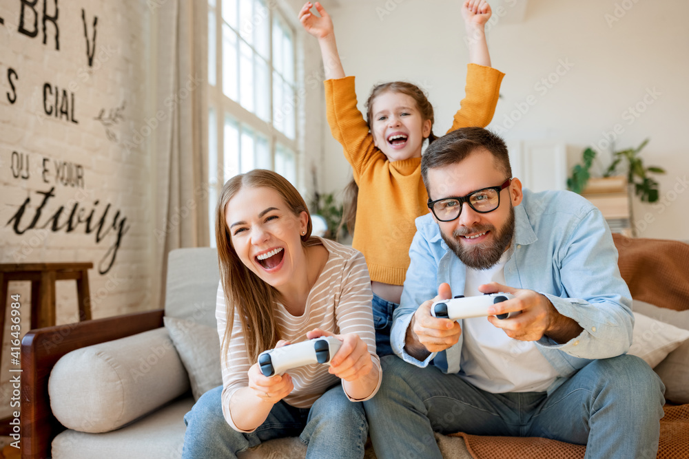 Wall mural Girl supporting parents playing videogame