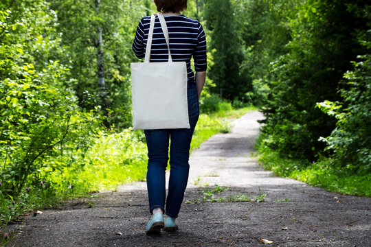 Woman in striped t-shirt holding tote bag mockup