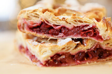 a piece of cherry pie on the dining table. The food is ready to eat. Puff pastry. kitchen utensils for cooking