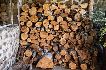 Big pile of firewood wood brushwood in stone house entrance natural background