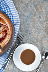 Sweet pie served with a cup of drink on a wooden board