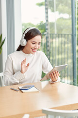 Obraz premium Freelance business woman using tablet working call video conference with customer in workplace in living room at home.