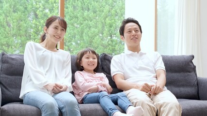 ソファに座ってリラックスする親子