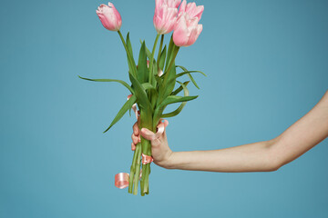 Bouquet in woman hands with gift holiday Valentine Day blue background