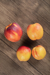 Red and yellow peaches isolated on a wooden deck