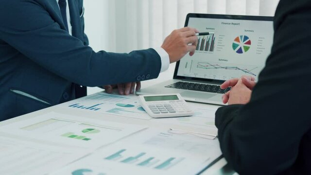 Employees are working together in the office, analyzing the company's financial data.