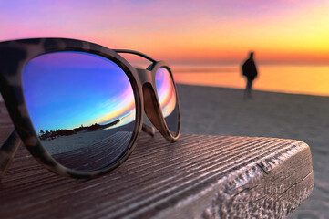 Fototapeta na wymiar Sunglasses and sunset and sea images