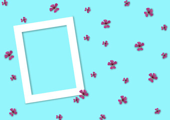 Beautiful flower arrangement. White photo frame and pink flowers on a gentle blue background. Flat lay, top view. white frame on blue background
