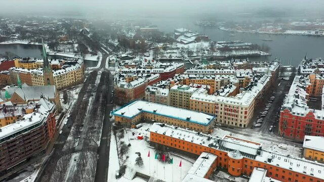 Snowstorm in Stockholm, aerial drone fottage flying over buildings and streets