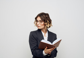 Woman in classic suit with open book glasses on face cropped view