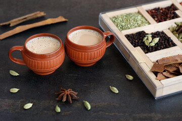 Top view of Indian herbal Masala Chai or traditional beverage tea with milk and spices Kerala India. Two cups of organic ayurvedic or herbal drink India, good in winter for immunity boosting.
