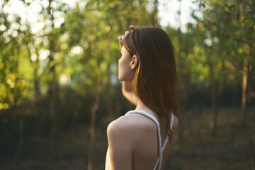 attractive woman outdoors in the forest green trees grass summer sunset