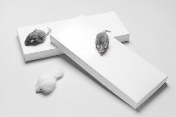 Creative composition with toy mice on light background