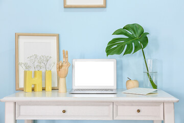 Wooden hand with laptop and decor on table in interior of room