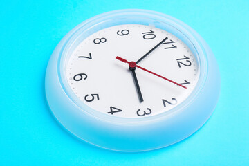 Stylish clock hanging on color wall, closeup