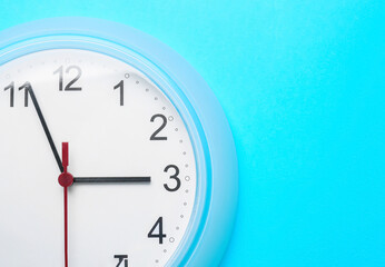 Stylish clock hanging on color wall, closeup