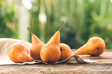 Fresh ripe pears on table against blurred background