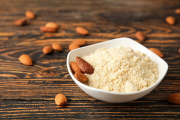 Bowl with almond flour on wooden background