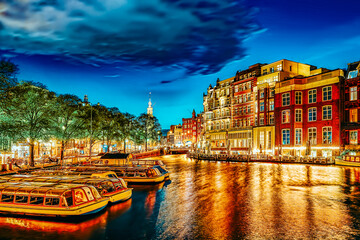 Famous Amstel river and night view of beautiful Amsterdam city. Netherlands