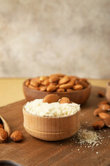 Bowl with almond flour on wooden background
