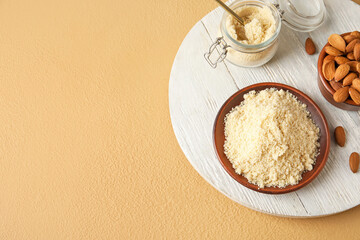 Plate with almond flour on color background
