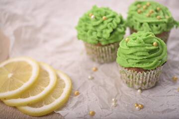 Cupcakes with decorative elements and lemon slices on the table