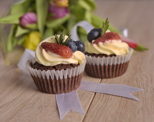 Cupcakes with berries and buttercream on the table
