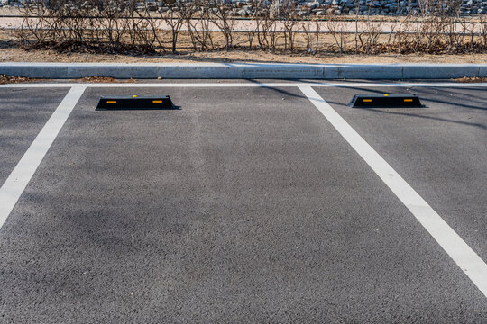 Empty parking spaces marked with white lines in paring lot of wilderness park.