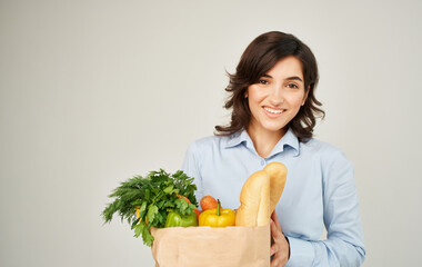 Cheerful pretty woman in a shirt with a package of products household healthy food delivery