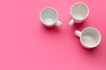 Empty cups on color background