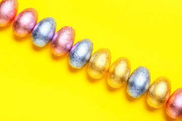 Sweet chocolate eggs on color background