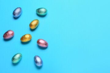 Sweet chocolate eggs on color background