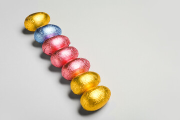 Sweet chocolate eggs on grey background
