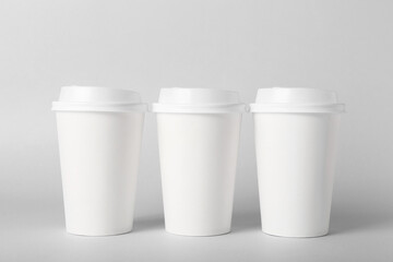 Blank takeaway cups on light background