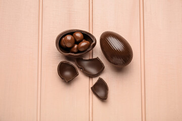 Chocolate Easter eggs on color wooden background