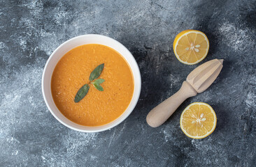 Obraz na płótnie Canvas A white bowl of lentil soup with slices of lemon