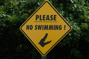 A yellow no swimming sign as a warning of alligators