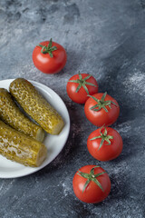 A white plate of pickled cucumbers with tomatoes