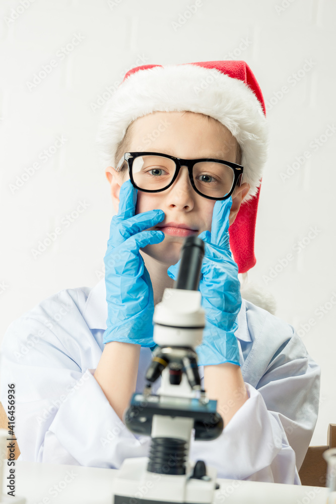 Wall mural student learning chemistry. positive joyful smart boy testing and using a microscope in science clas
