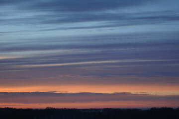 Fototapeta na wymiar Colorful sunset in winter. Striped clouds in the sky