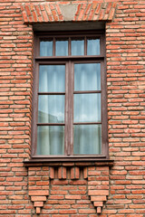 Fototapeta na wymiar Wall of red bricks with window close-up
