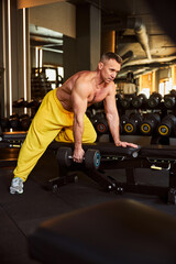 Naklejka premium Professional fitness coach doinf exercises with bench and dumbbells