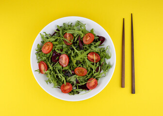 salad with tomatoes and herbs on yellow background