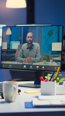 Woman freelancer discussing with client on video call at midnight from business office using headphone. Corporate team using group conference technology talking on webcam during online meeting