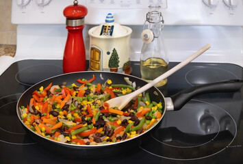 Frying pan with vegetable mix on the stove top.